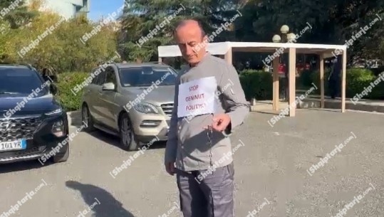 Sot seanca, Dashnor Sula me parullë-protestë të ngjitur në trup dhe pranga në duar para parlamentit: Stop dënimit politik! (VIDEO)